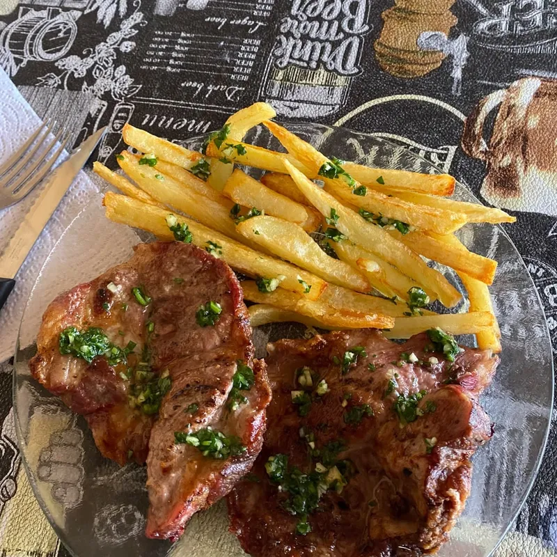 Plato de carne con papas fritas y perejil