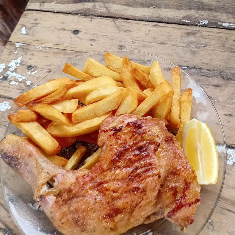 Pollo a la parrilla con papas fritas y limón